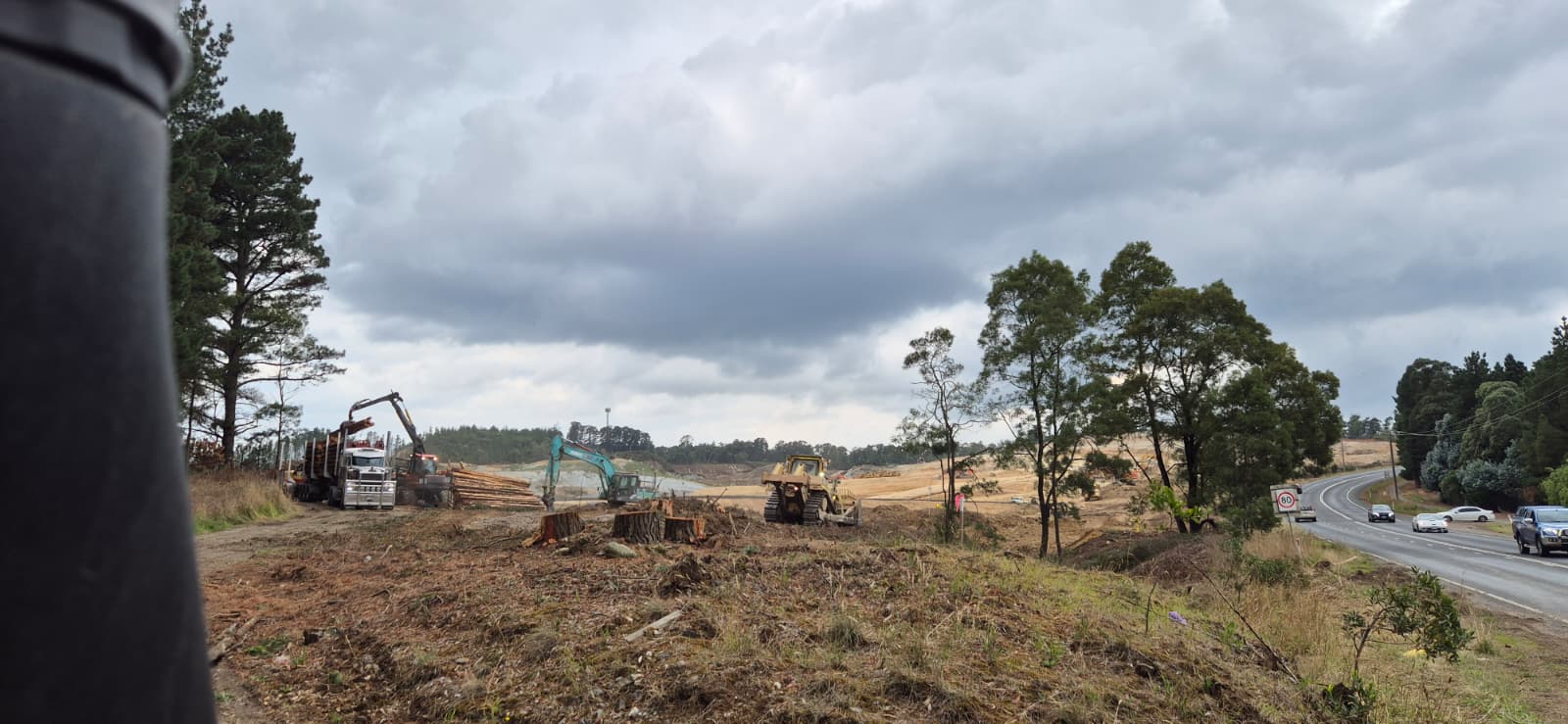 Log truck, excavator and dozer working the wider mine site