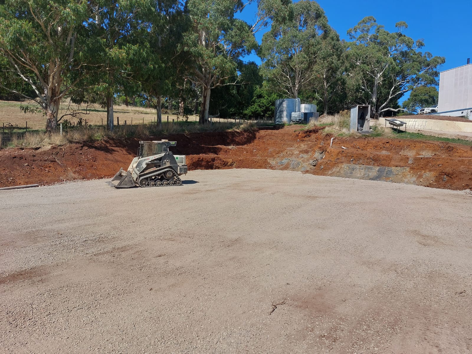 Compacted gravel hardstand pad prepared by a tracked loader