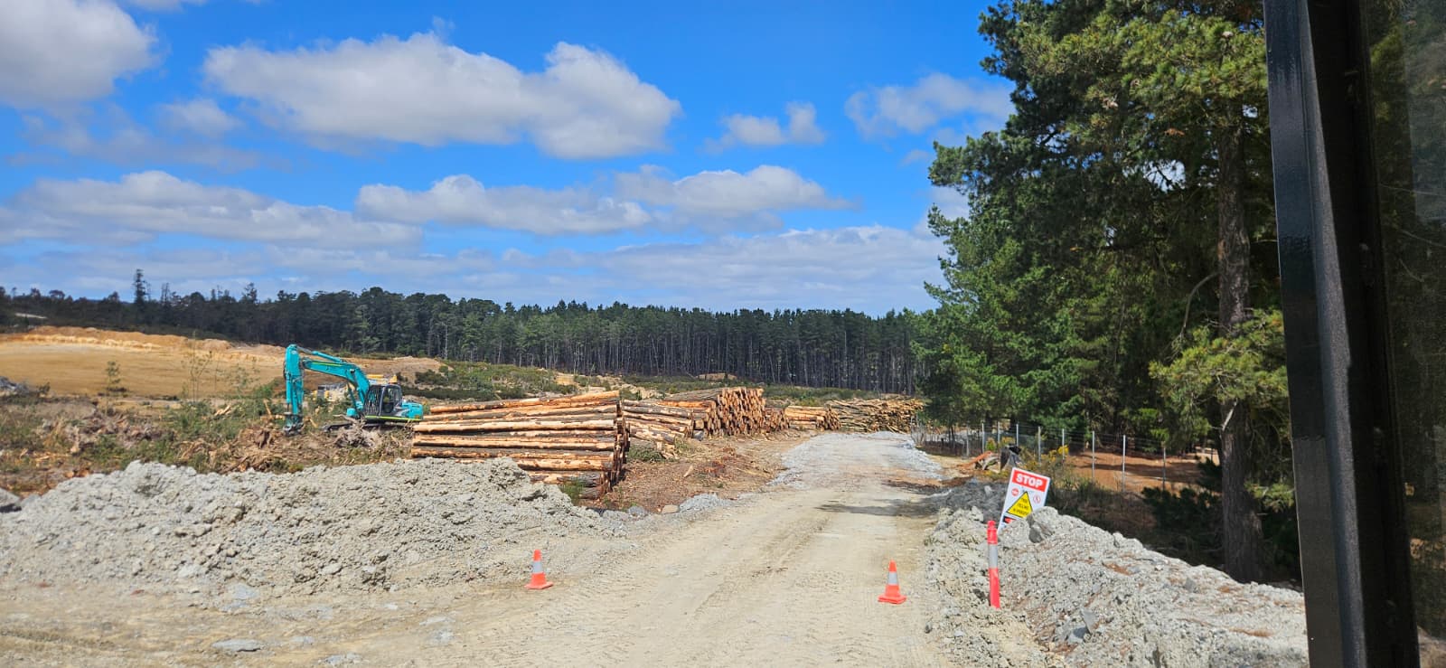 Log stacks beside the haul road with traffic controls in place