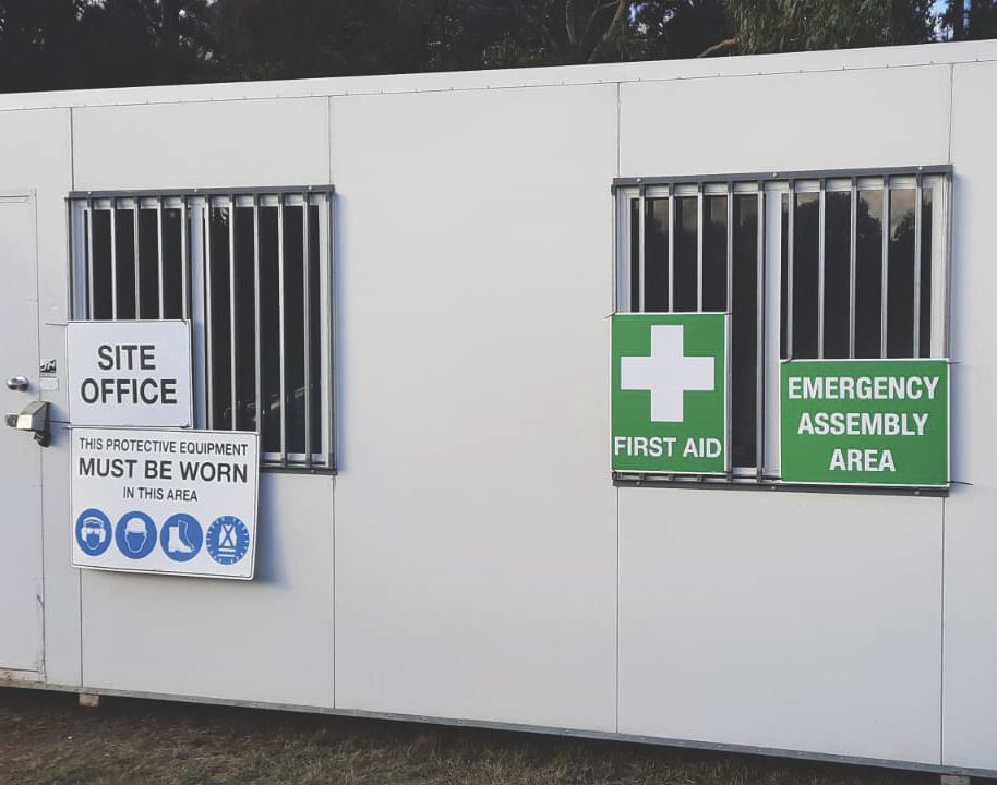 Site office with first aid and emergency assembly area signage